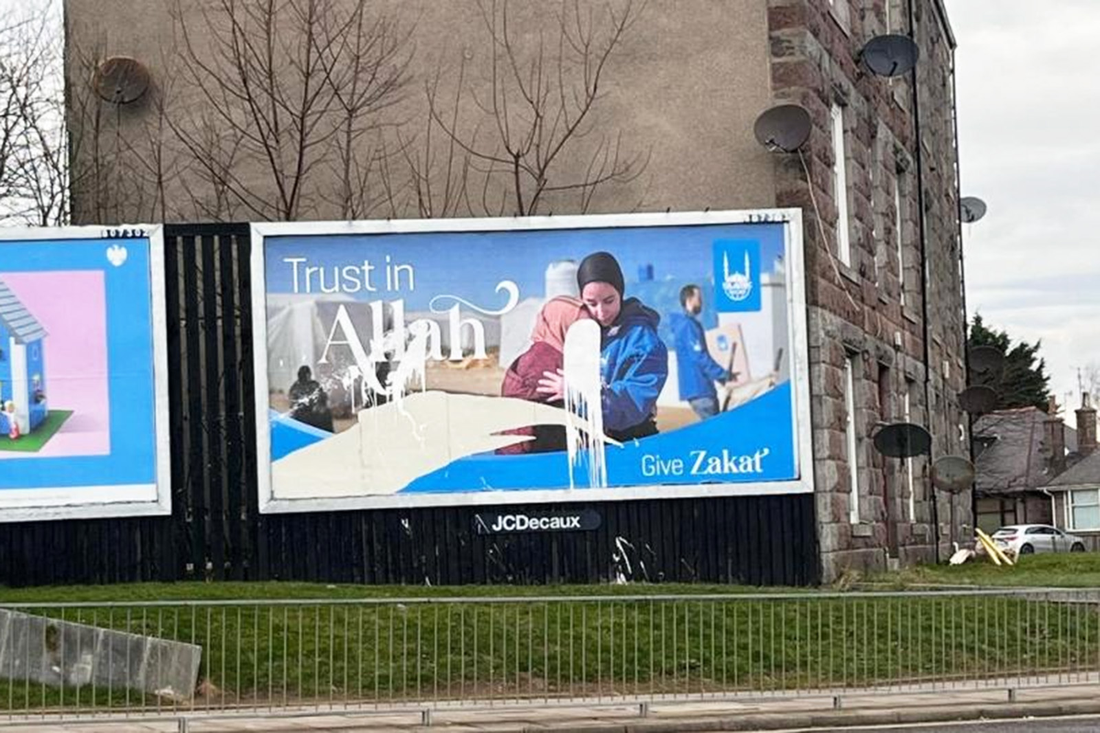 A photograph of an Islamic Relief zakat billboard in Aberdeen, vandalised with white paint