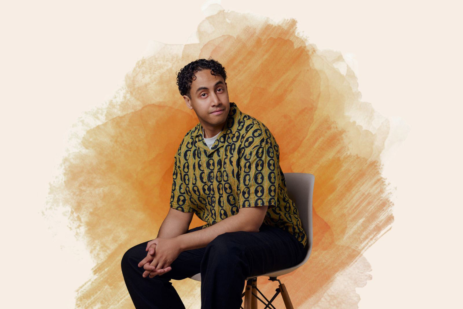 A portrait photograph of Omar Badawy, seated on a chair and wearing a Hawaiian shirt