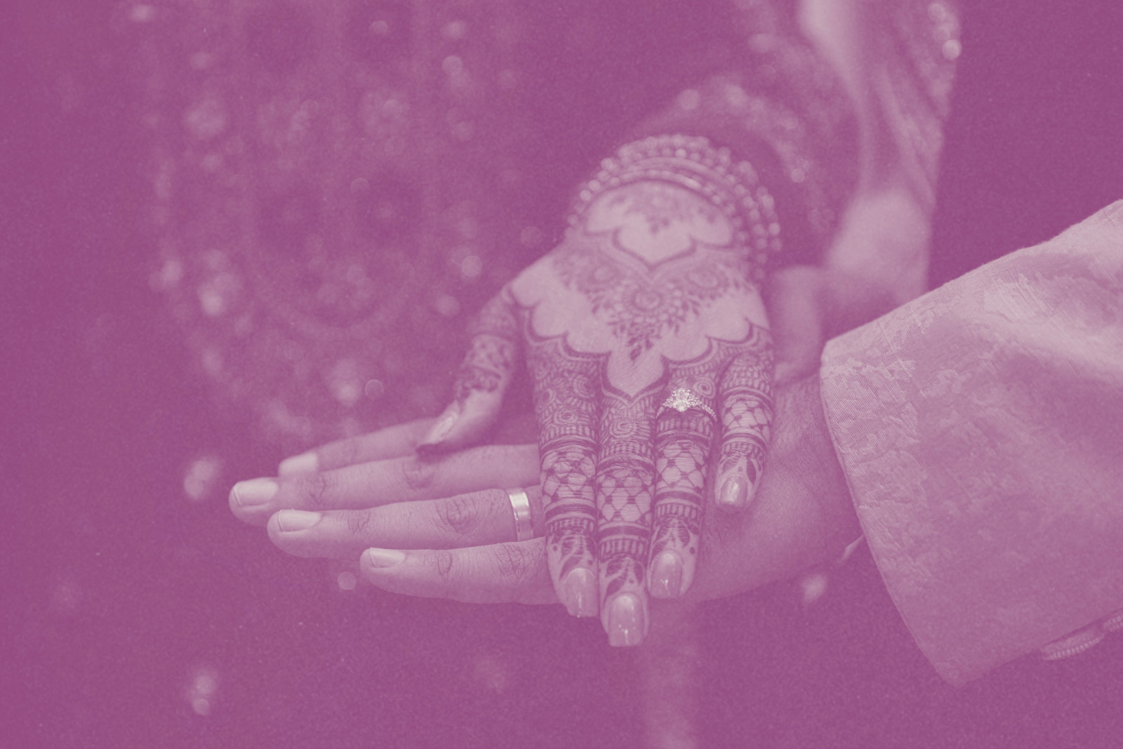 A stock image of a bride laying her hand on her groom's after a nikah ceremony