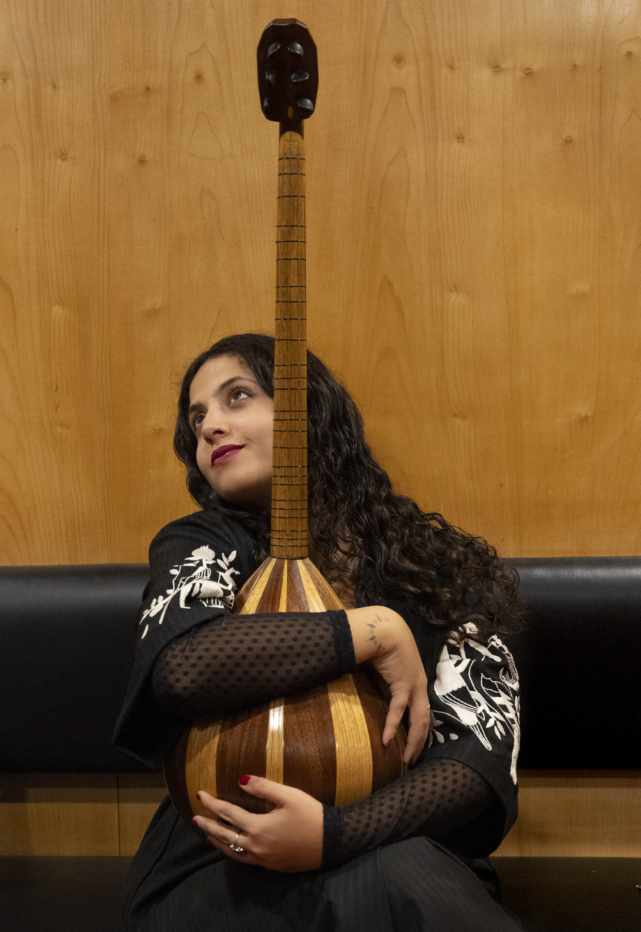 A portrait image of Lebanese musician Farah Kaddour holding her instrument, a buzuq