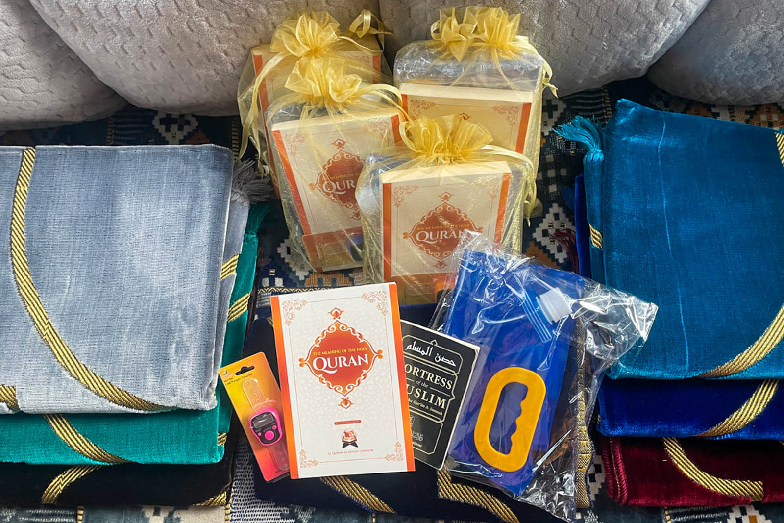 A photograph showing Qur'ans, rugs and wudu ablution kits for MLXN prayer packs