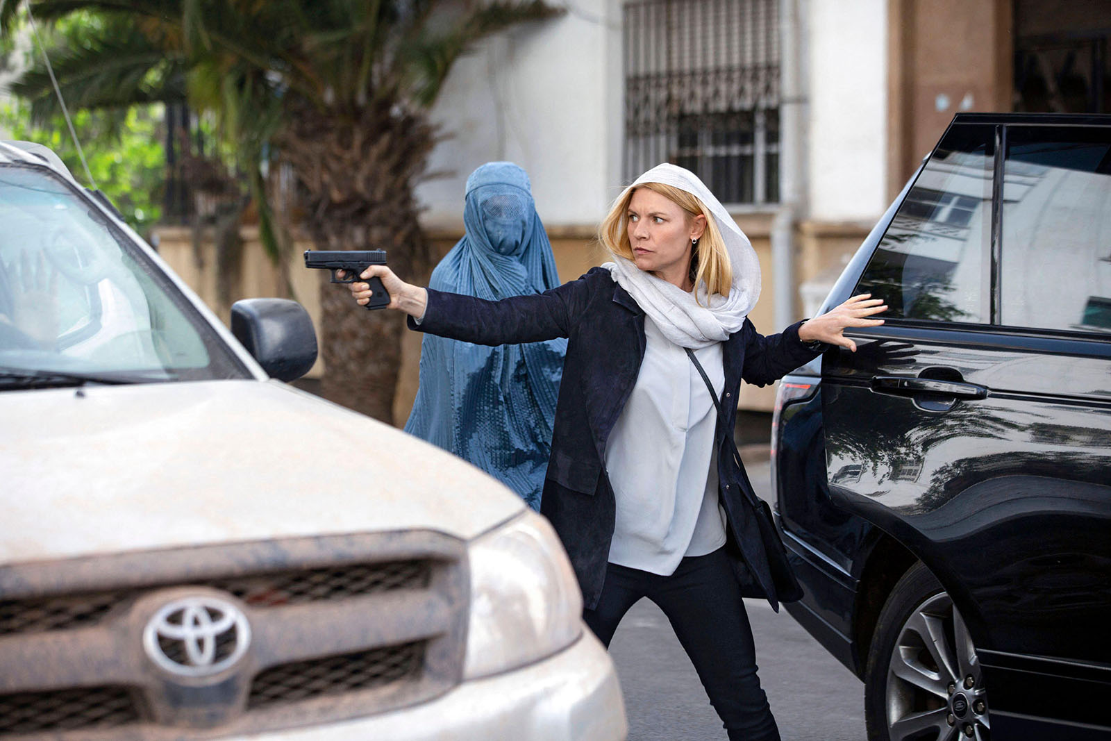 A production still of Claire Danes as CIA officer Carrie Mathison, exiting a car wielding a handgun, in the eighth and final season of Homeland, broadcast in 2020