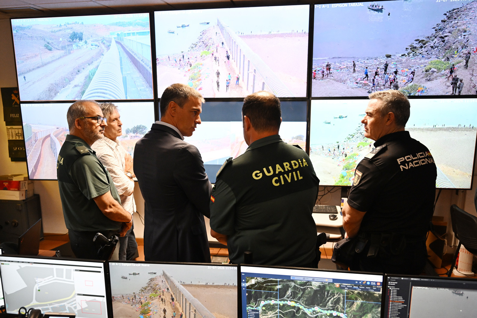 A photograph of Spain's prime minister, Pedro Sánchez, in a Ceuta surveillance facility with four others watching CCTV footage of the mass crossing, 31 July 2026
