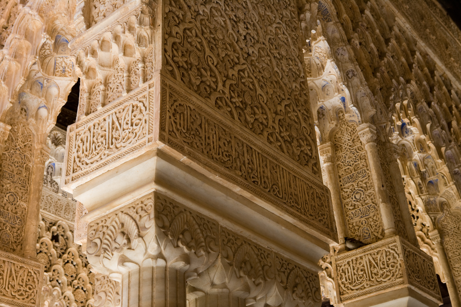 A photograph showing detail of carvings at the top of stone pillars in the Alhambra, Granada, southern Spain