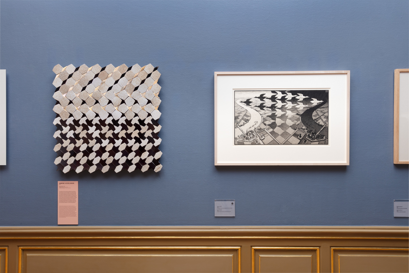 A photograph of the Escher and Islamic Art exhibition in the Hague, showing a work by Moroccan artist Amine Asselman to the left, next to an Escher painting