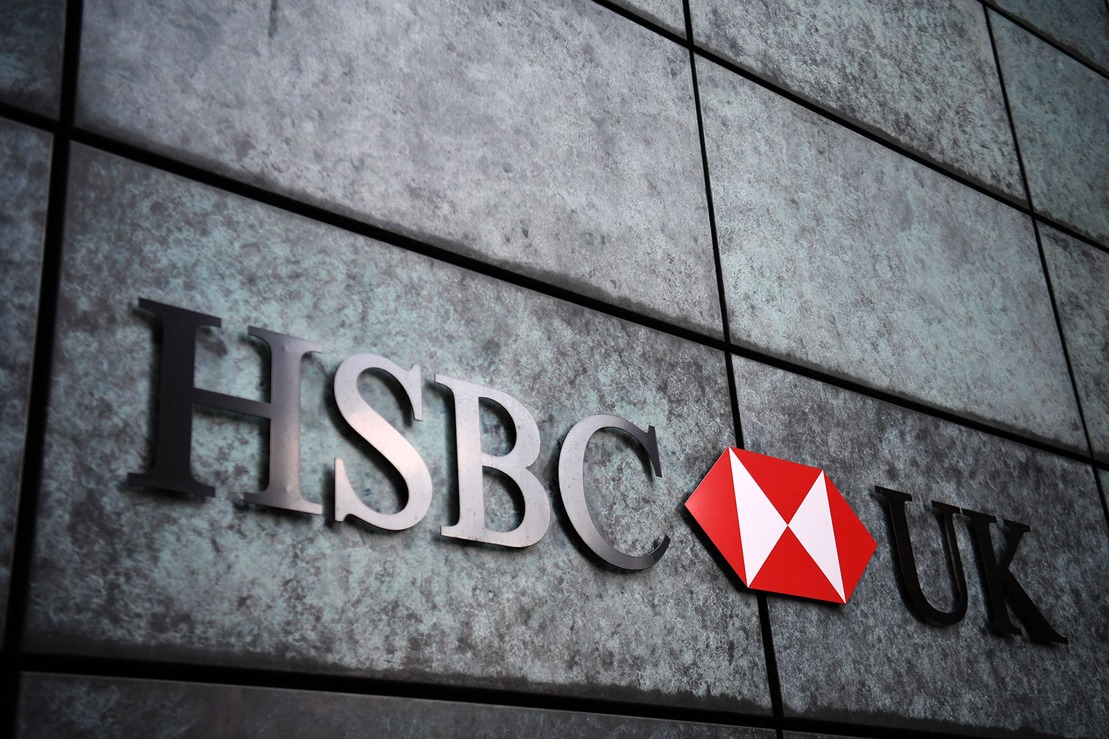 A close-up HSBC logo on a grey stone wall. This is probably the side of a bank somewhere.