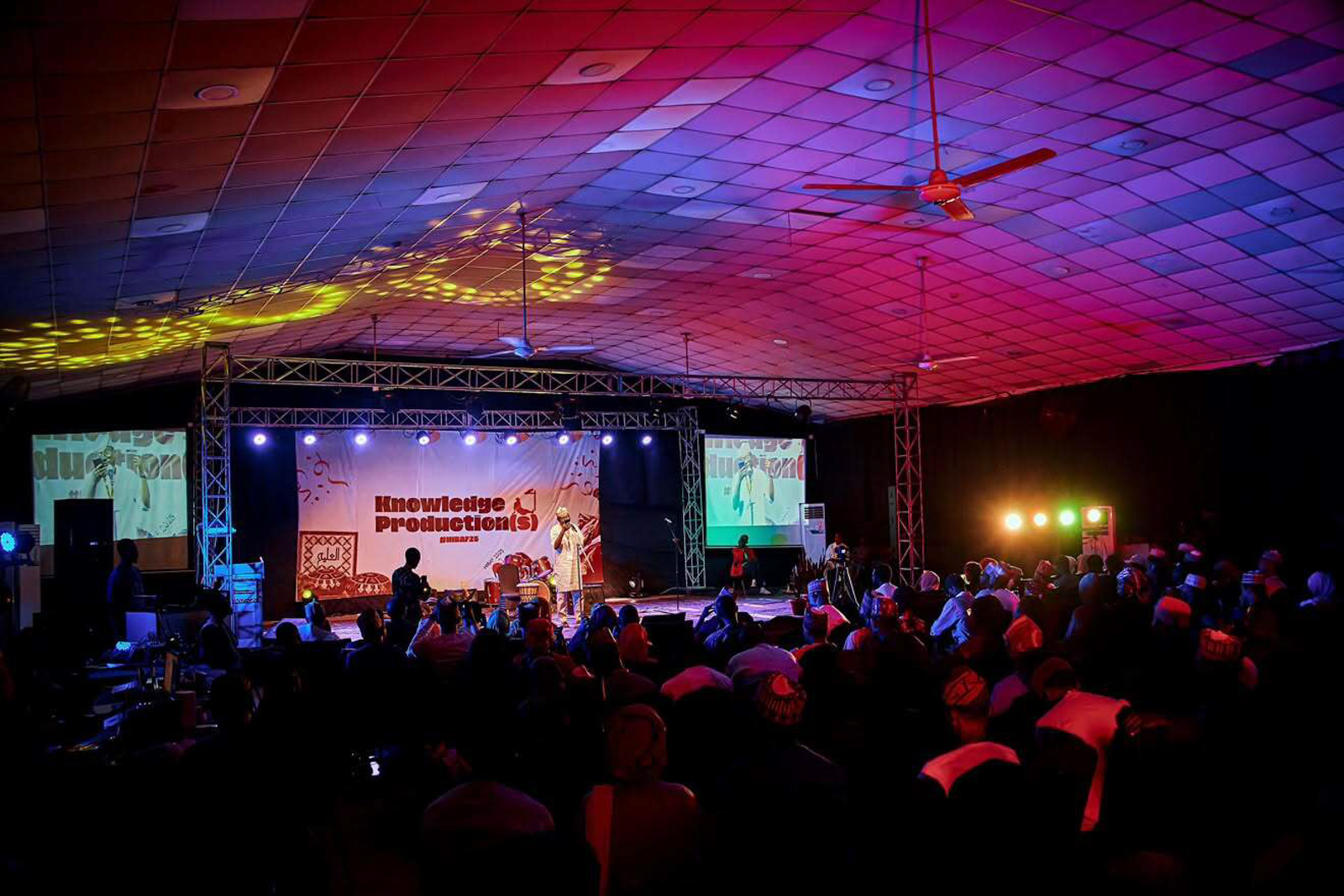 A photograph of a Hausa literature festival event in Nigeria, taking place in what looks like a temporary covered outdoor stage