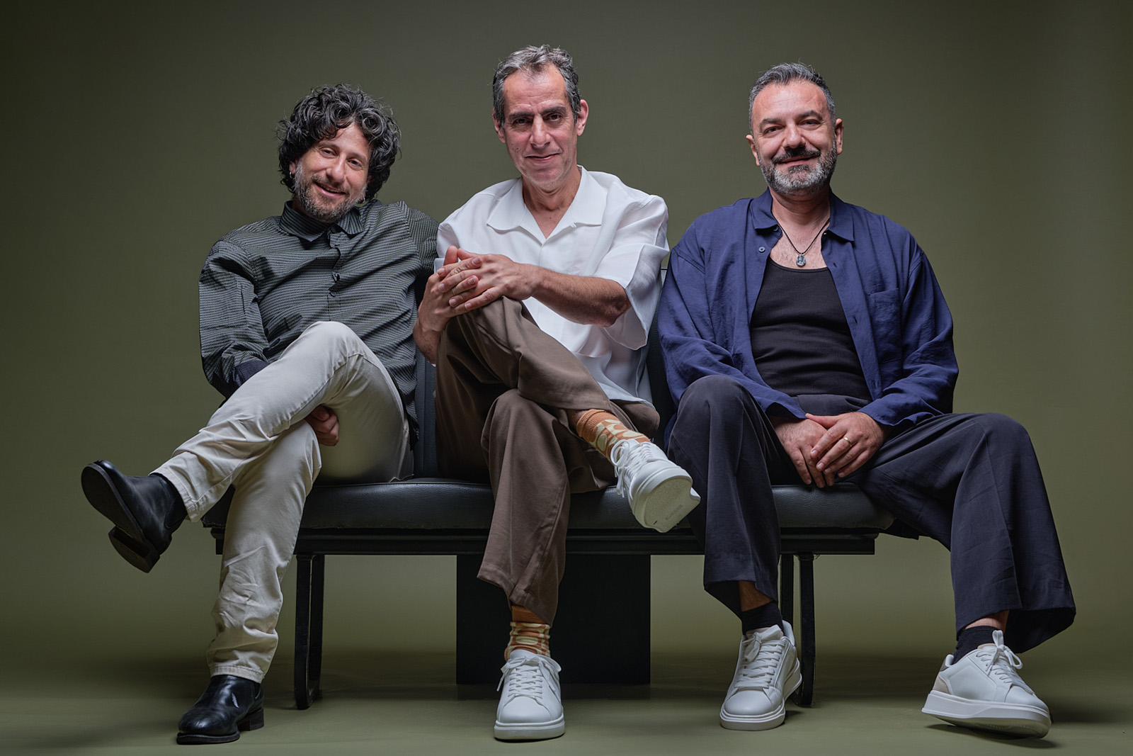 A photograph of the members of cross-cultural trio L’Antidote, seated on a bench 
