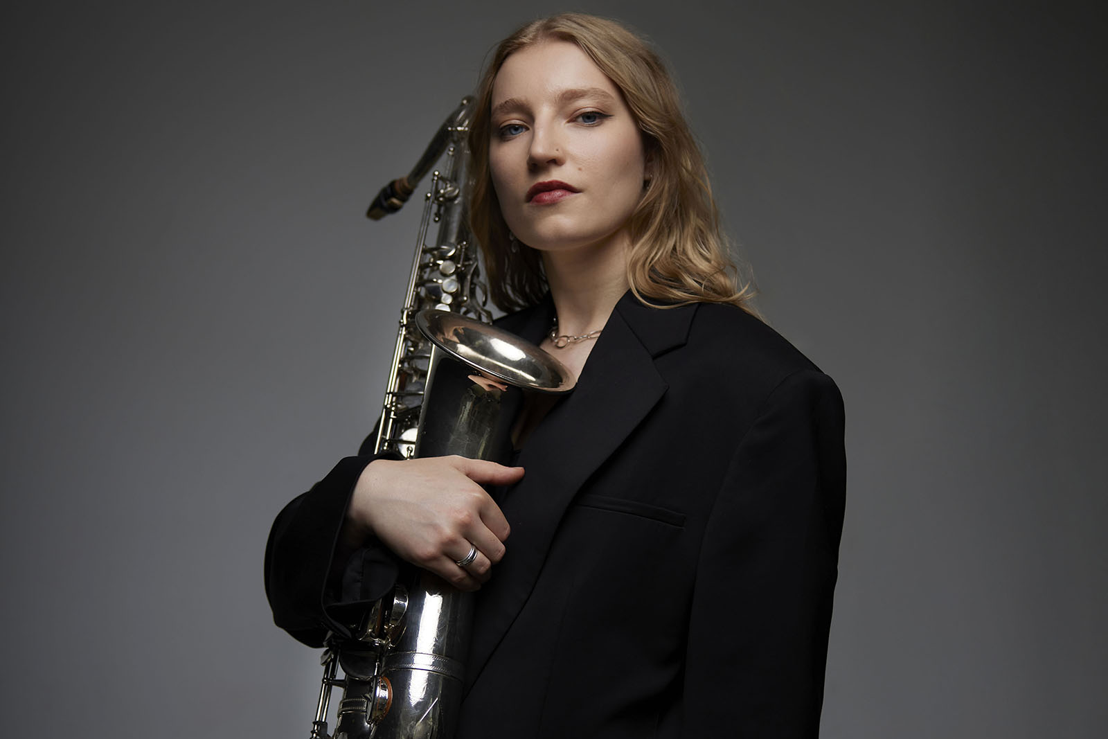 A photograph of saxophonist Emma Rawicz holding her instrument